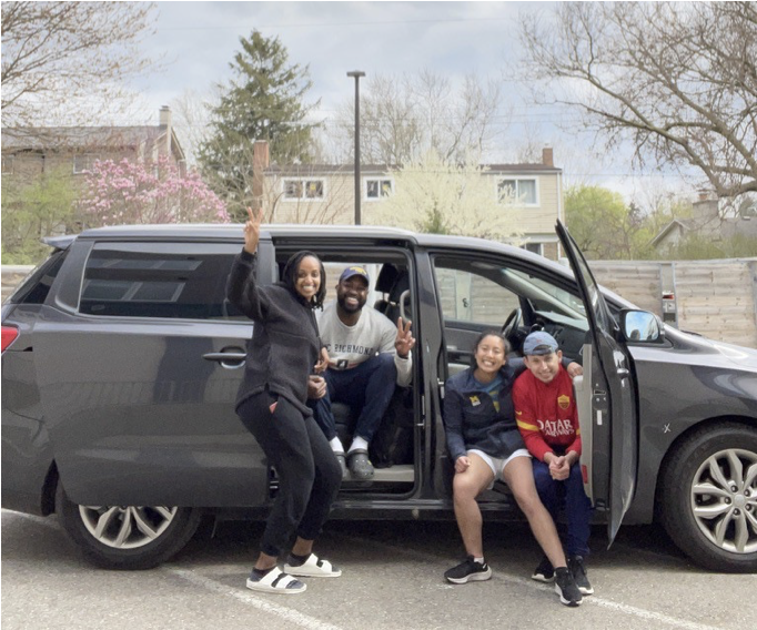 Two men and two women of various ethnicities from team Geek Squad, posed in a van.