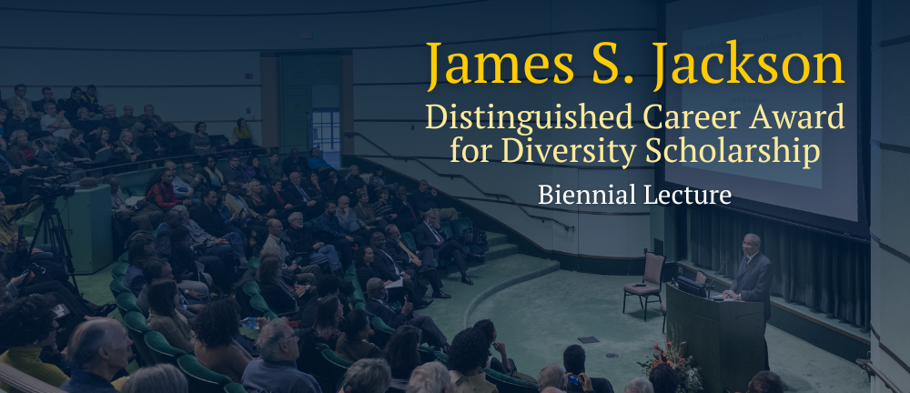 Lecture being given to a large group of people in an auditorium.