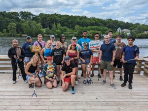 A group of students stand with litter clean up supplies