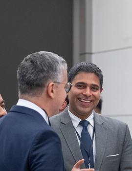 South Asian man speaking with white man