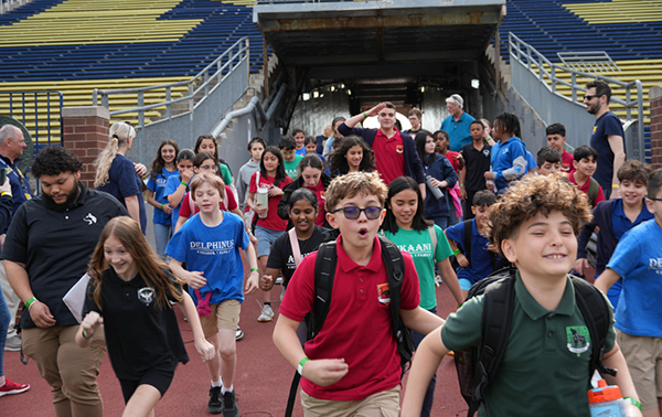 Large group of children running into a stadium