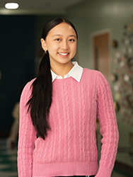 Whitney Zhang, in pink, in an office hallway.