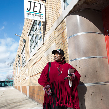 Black woman wearing red, preparing to enter the Jefferson East building in Detroit