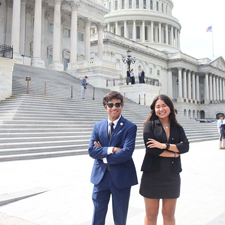 Male and female graduate students standing in front of the US Capitol