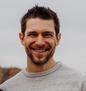 Adam Reimer headshot: white man with short dark brown hair and beard.