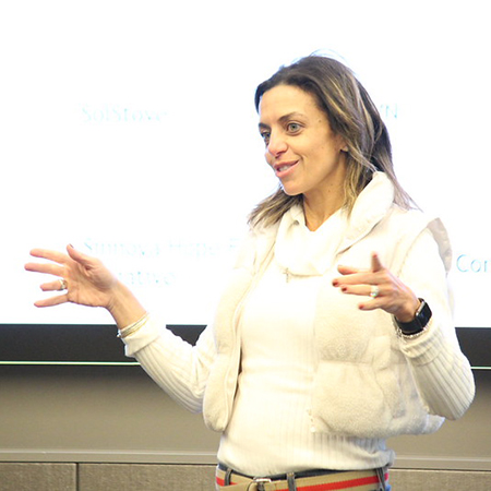 Adult female student presenting in front of a screen