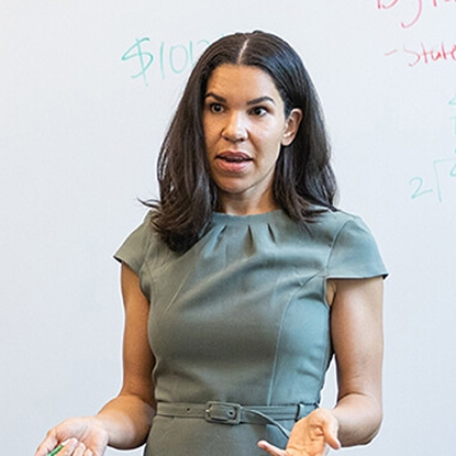 Tifani Sadek presenting in front of a white board