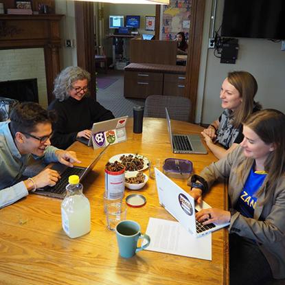 Diverse group of three women and one man at a table as part of the Ginsberg CTAC program