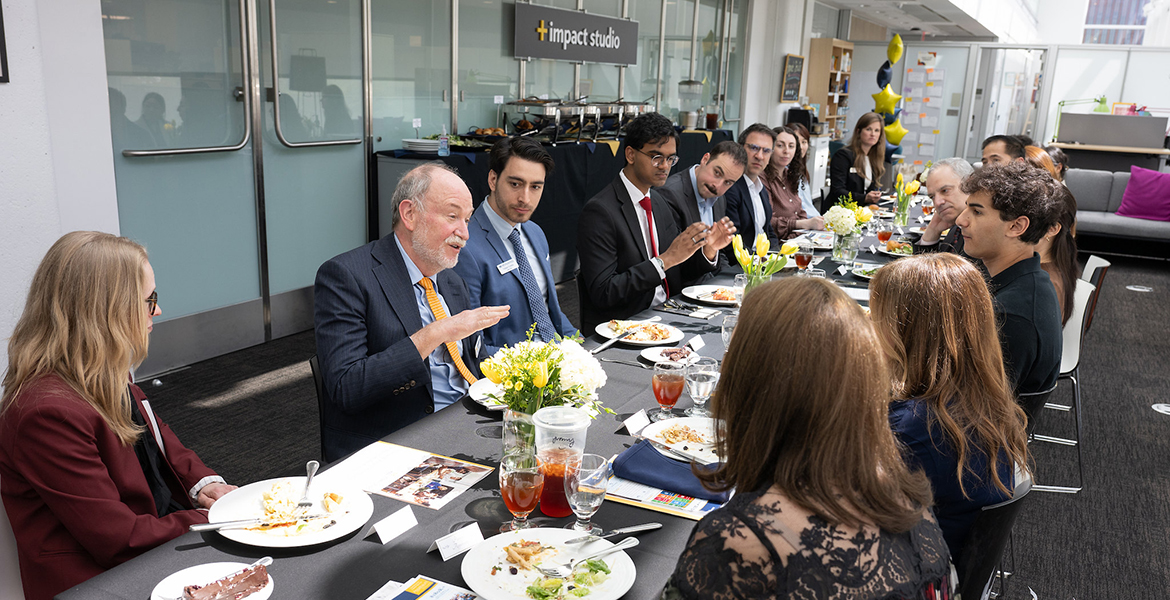 Jerry Davis and Cat Johnson at a table of 20 people, describing Business+Impact