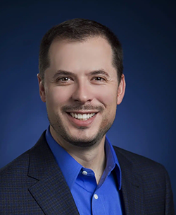 Chris Mueller portrait in front of blue background