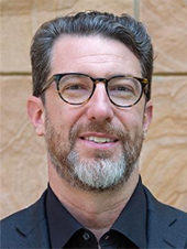Christopher Rider portrait in front of brick wall