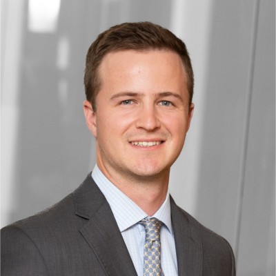 Portrait of Jason Outcalt in a suit in front of a gray background