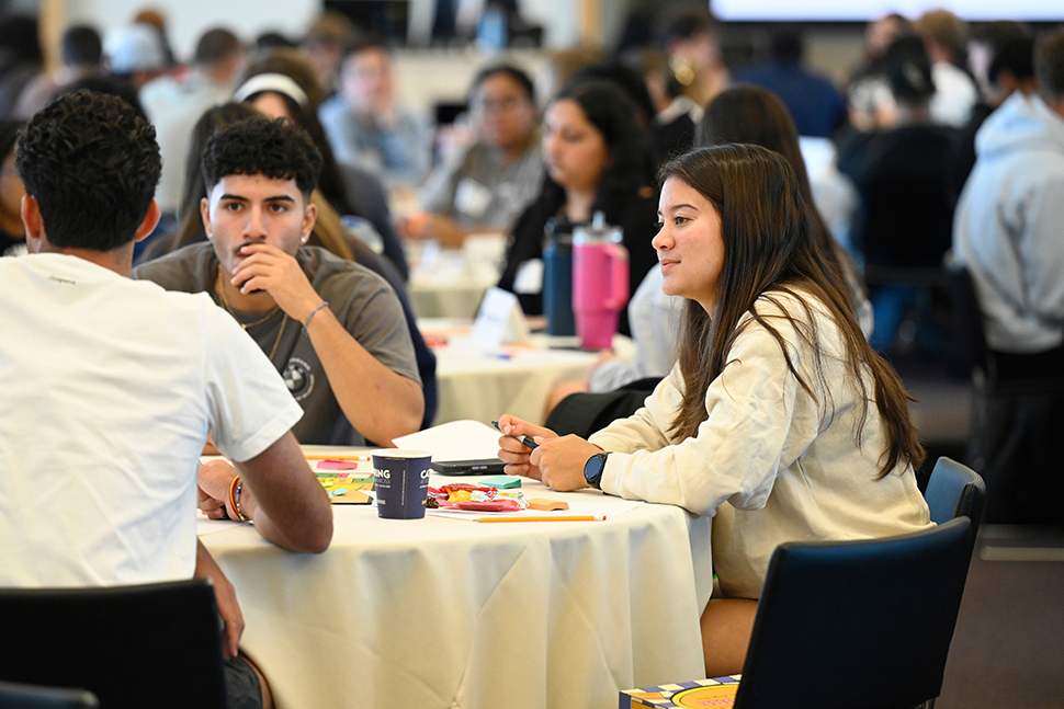 First year IMPACT students play a game of building a business, as they learn about using design thinking and business acumen